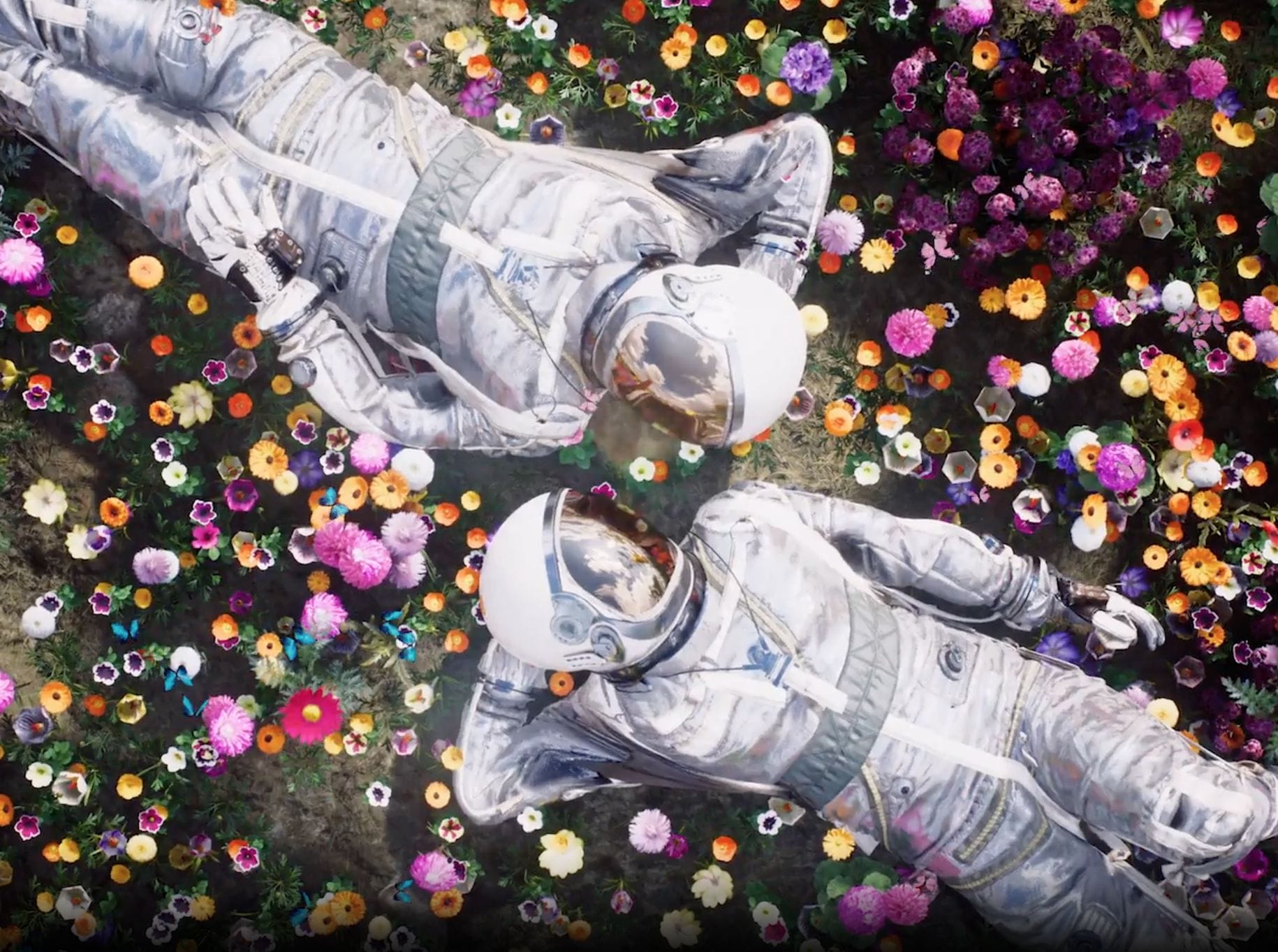 two astronauts laying on flower bed